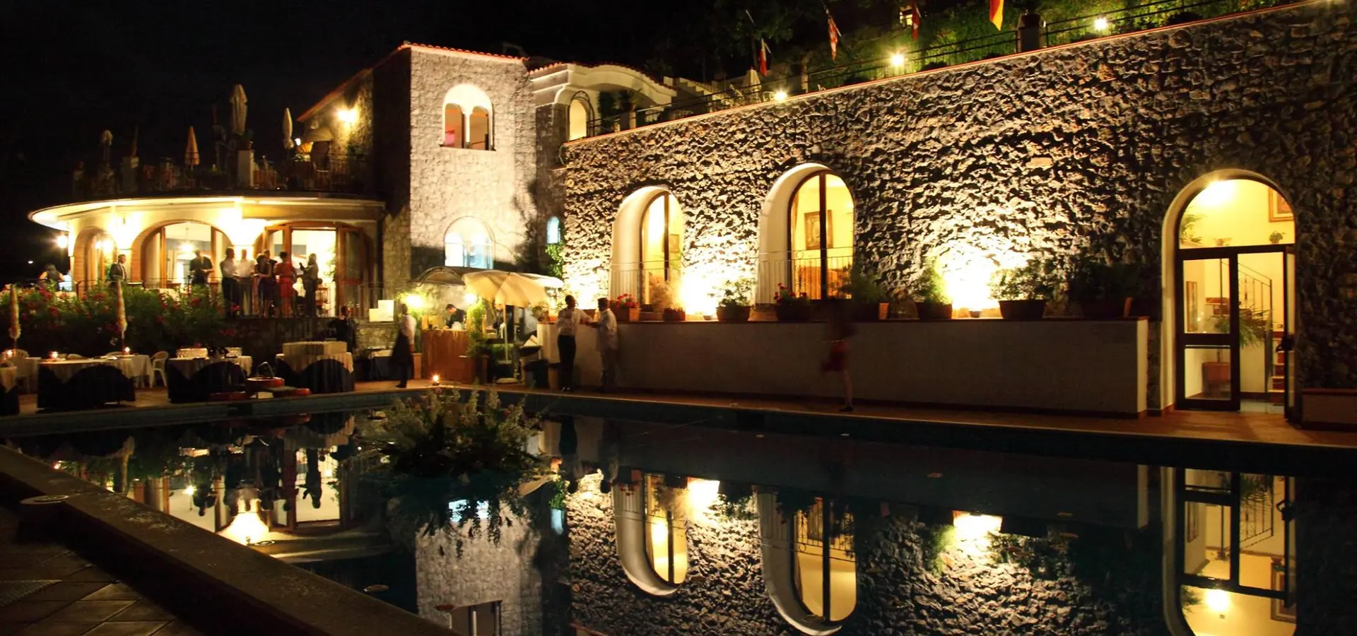 Villa Giuseppina illuminata di sera con la terrazza apparecchiata