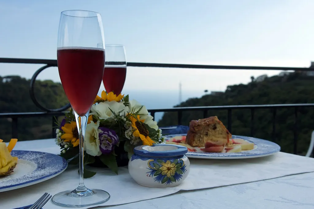 Un calice di vino rosato su un tavolo apparecchiato con fiori